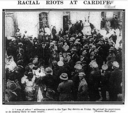 Western Mail newspaper clipping of a grainy black and white photo showing a multiracial crowd. The caption reads Racial Riots at Cardiff'.